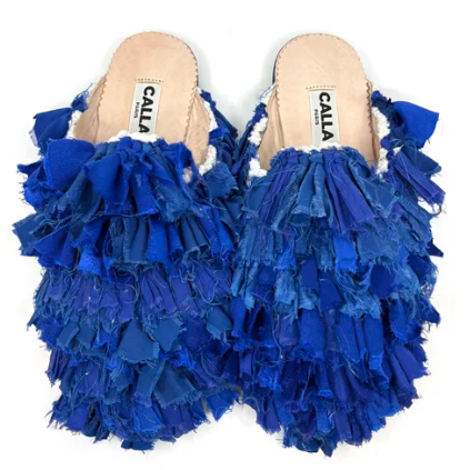 Pair of blue ruffled babouche with 'Calla' brand label on a white background